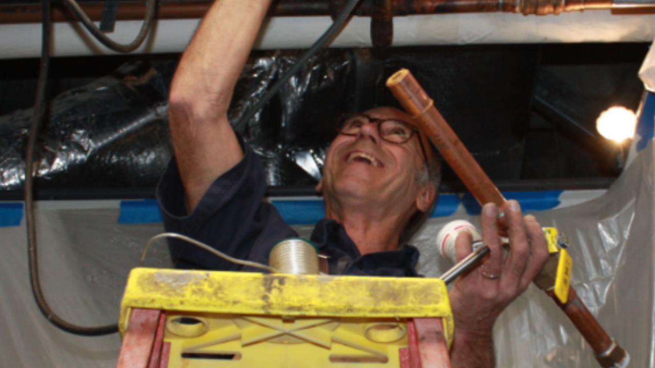 Photo of employee working with water pipes.