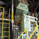 Industrial plant interior with control panel, gauges, yellow railings and pipes